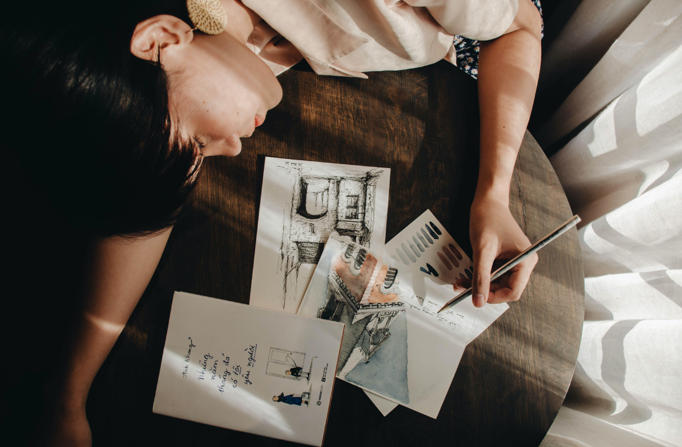 Boy sleeping on table next to painted pictures